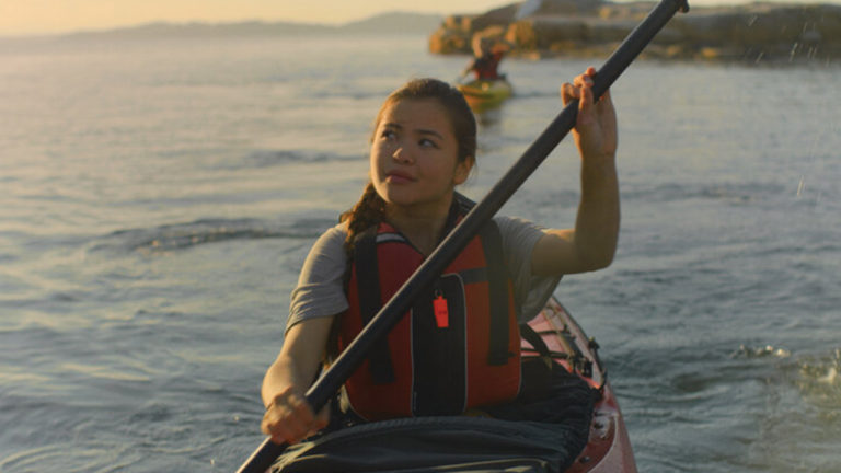 Kayaker traverses a calm lake.